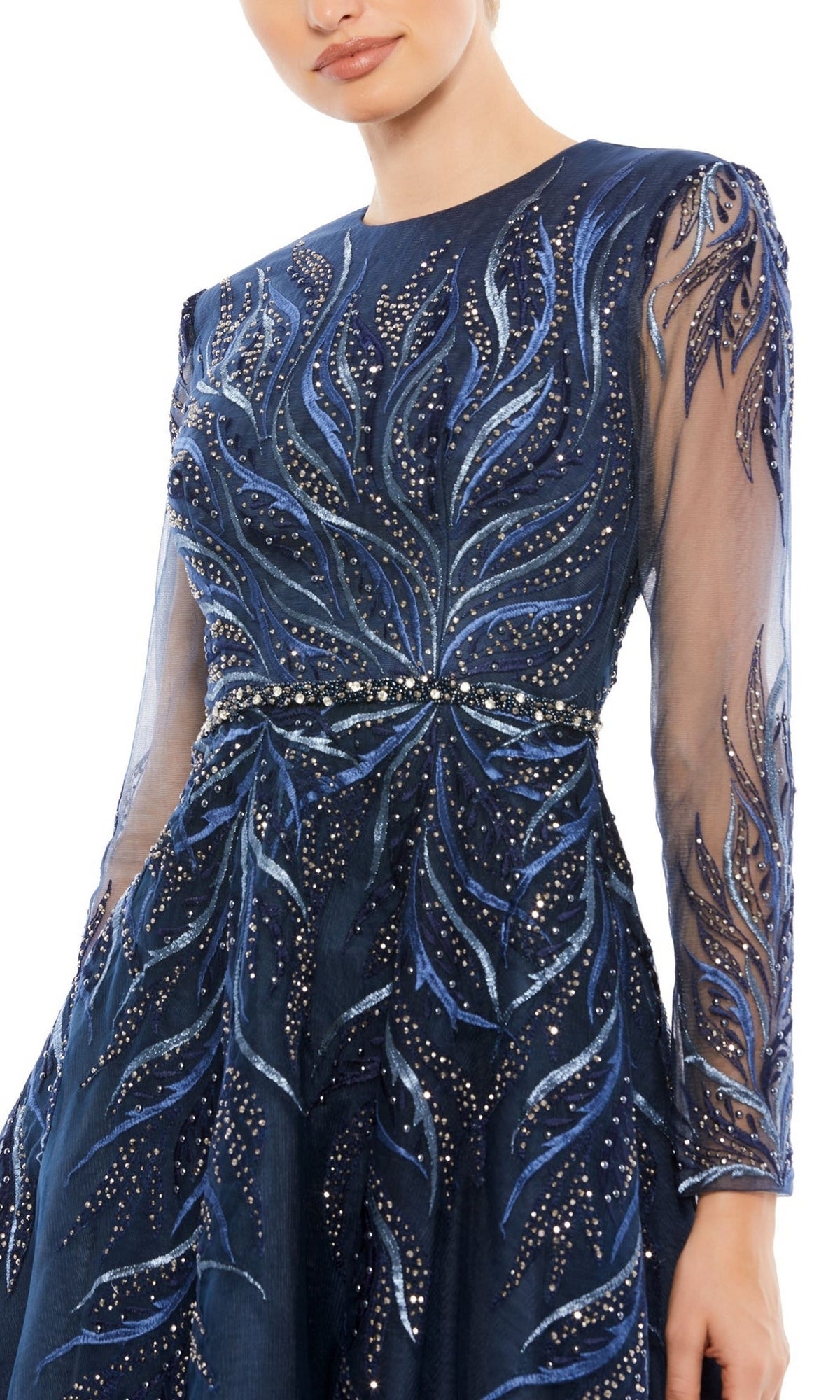 Woman wearing the Mac Duggal 11136 Blue Knee-Length Cocktail Dress, featuring sheer long sleeves and intricate beaded and embroidered leaf patterns.
